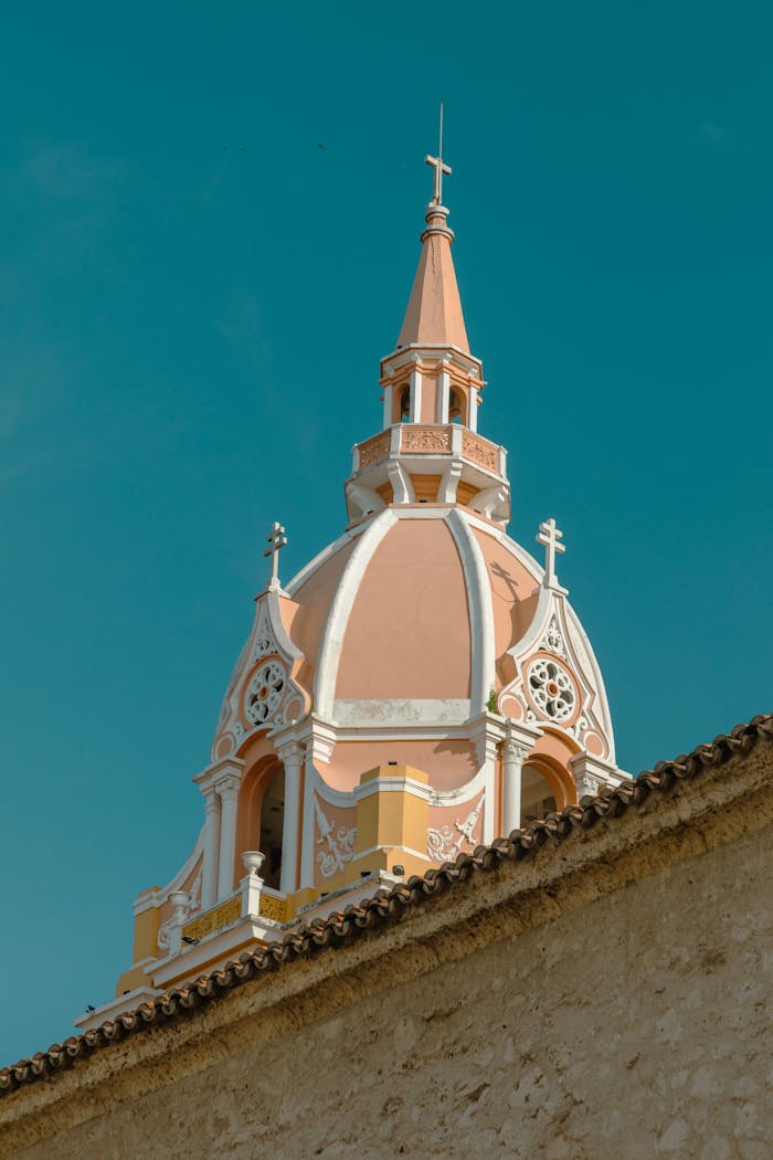 heros-img Photograph of a historic pink and white dome with intricate design against a clear blue sky.